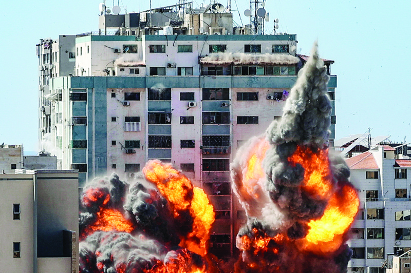 GAZA: A ball of fire erupts from the Jala Tower as it is destroyed in a Zionist airstrike in Gaza City on Saturday. - AFP n