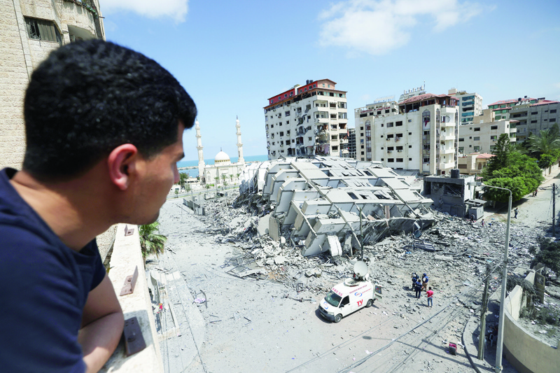 GAZA CITY: A Palestinian man looks at a destroyed building in Gaza City, following a series of Zionist airstrikes on the Gaza Strip early yesterday. - AFPn