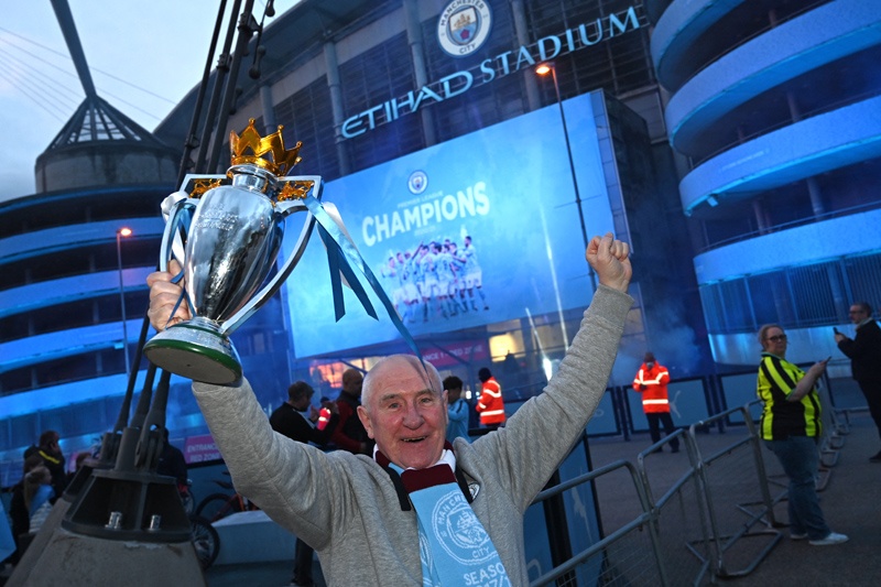 MANCHESTER: Manchester City fans celebrate their club winning the Premier League title, outside the Etihad Stadium in Manchester, north west England, on Tuesday. - AFPnn