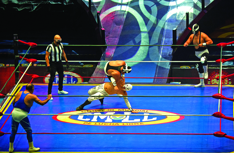 MEXICO CITY: Wrestlers fight as part of the Copa Dinastias event of the World Wrestling Council (CMLL), at the Arena Mexico in Mexico City on Friday. - AFPnn