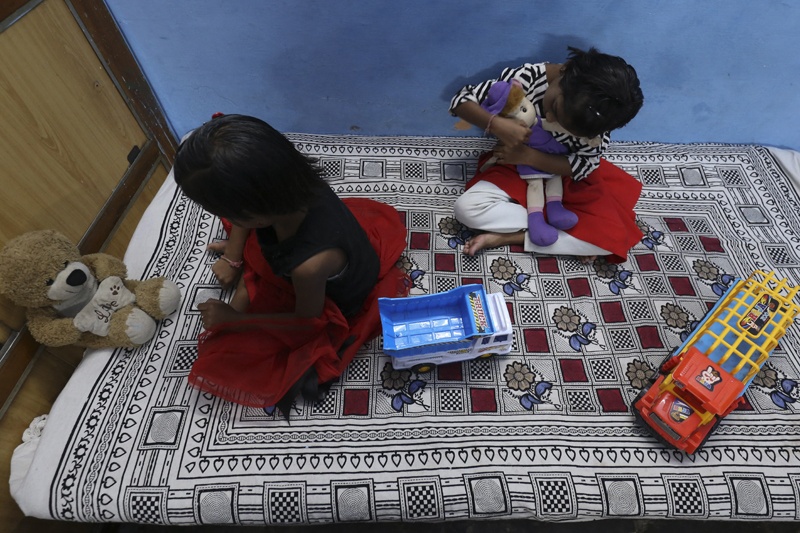 In this picture taken on May 11, 2021, twin sisters Tripti and Pari, who lost both their parents due to the Covid-19 coronavirus, play with their toys at a relative's home in Bhopal. - Thousands of children have lost at least one parent in the new pandemic wave ravaging India, where there were already millions of orphans. (Photo by Gagan NAYAR / AFP) / TO GO WITH AFP STORY children-health-India-coronavirus by Aishwarya KUMAR
