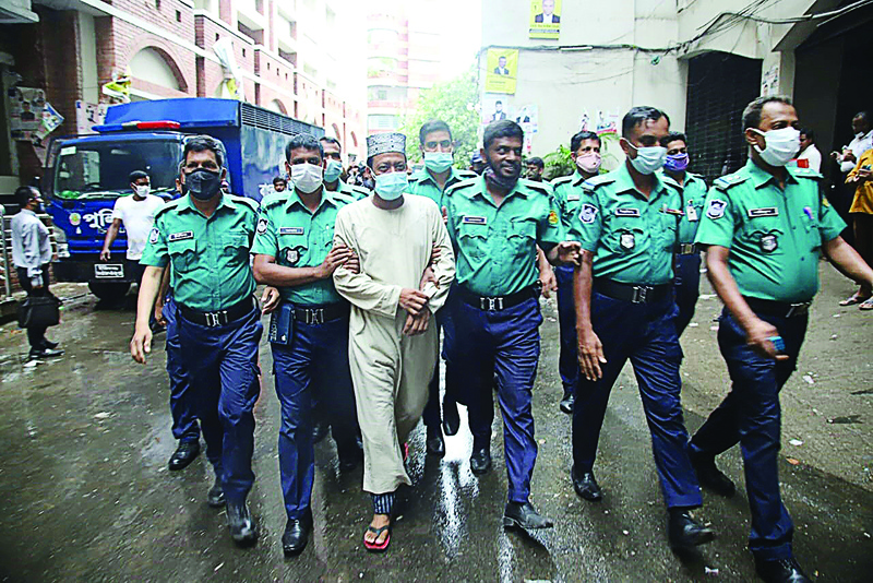DHAKA: Police personnel escort Amir Hamza, one of the country's most popular Islamic preachers, whose rallies draw tens of thousands of people, on charges of inciting militants, following his arrest in Dhaka yesterday.-AFP n