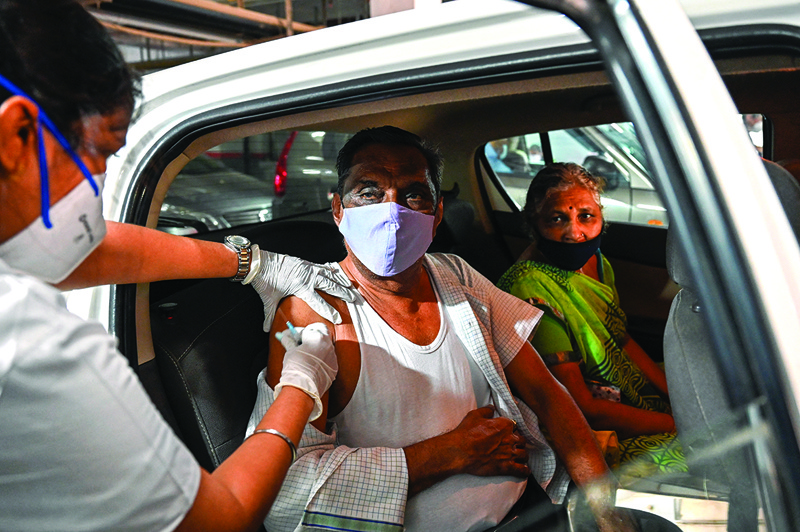 MUMBAI: An elderly man gets inoculated with a dose of Covishield vaccine against the COVID-19 coronavirus at a drive-in vaccination facility in Mumbai yesterday.-AFPn