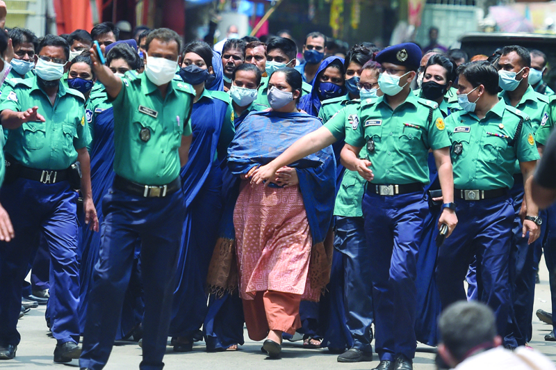 DHAKA: Police escort investigative journalist Rozina Islam (center) to a court in Dhaka yesterday, a day after being arrested on accusation of stealing documents and taking images by the health ministry.-AFP n