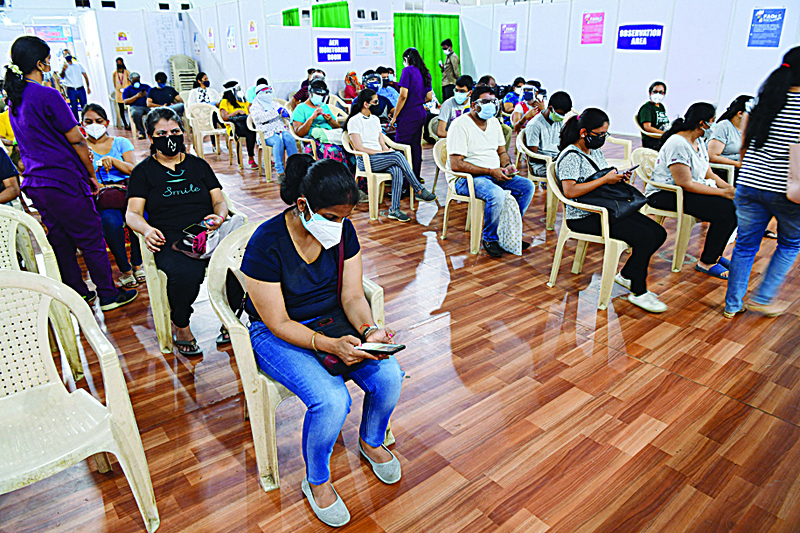 MUMBAI: People sit in an observation area after getting inoculated with a dose of Covishield vaccine against the COVID-19 coronavirus at the BKC Jumbo vaccination center in Mumbai yesterday on the second day of India's vaccination drive to all adults. - AFPn