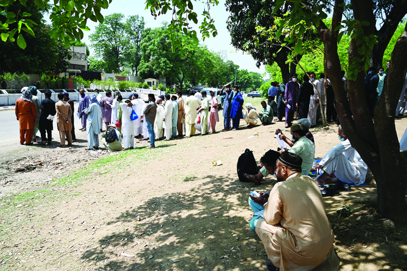 ISLAMABAD: In this picture taken on May 19, 2021, Pakistani nationals, wearing facemasks wait in a queue to apply for a visa outside Afghanistan's embassy in Islamabad. - AFPn