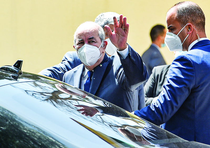 ALGIERS: Algeria's President Abdelmadjid Tebboune waves as he departs after voting at a polling station in Bouchaoui, on the western outskirts of Algeria's capital Algiers yesterday during the 2021 parliamentary elections. - AFPnn