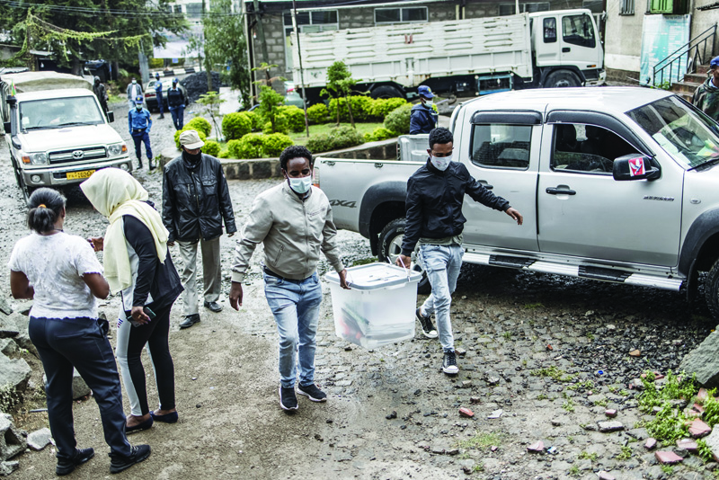 ADDIS ABABA: Electoral officials carry voting material at a polling station in Addis Ababa yesterday. - AFPn