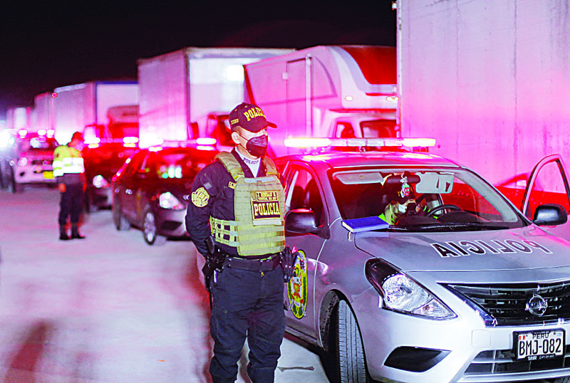 LURIN: Peruvian police forces stand guard next to a fleet of trucks as they prepare to leave Lurin, near Lima, on their way to distribute voting material to voting stations ahead of the presidential election runoff. – AFPnnn