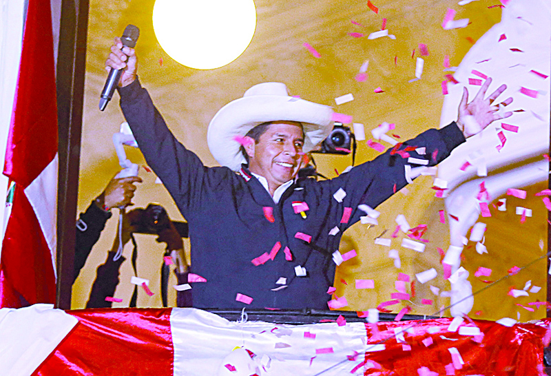 LIMA: Peruvian leftist presidential candidate Pedro Castillo of Peru Libre waves to supporters from his party headquarters' balcony in Lima.-AFP n