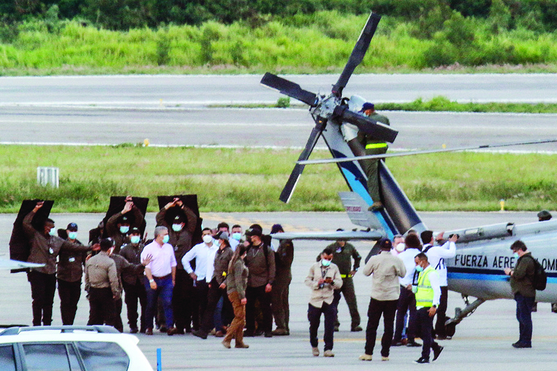 CUCUTA, Colombia: Colombia's President Ivan Duque (left) walks surrounded by bodyguards close to the presidential helicopter at the tarmac of the Camilo Daza International Airport after it was hit by gunfire in Cucuta, Colombia.-AFP n