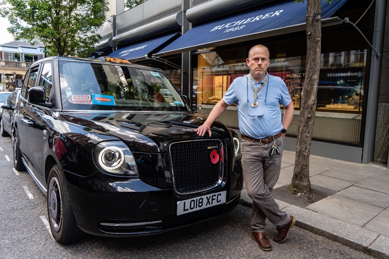 London taxi driver Barry Ivens, 53, poses for a photograph next to his cab in central London on May 27, 2021. – AFPn