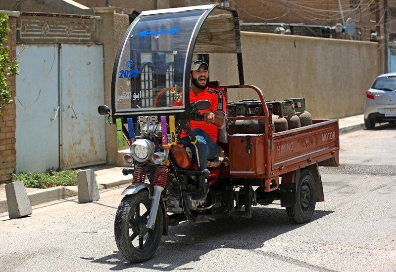 Deliveryman Mountazar Abbas announces the arrival of his cylinder-laden rickshaw by singing. - AFPn