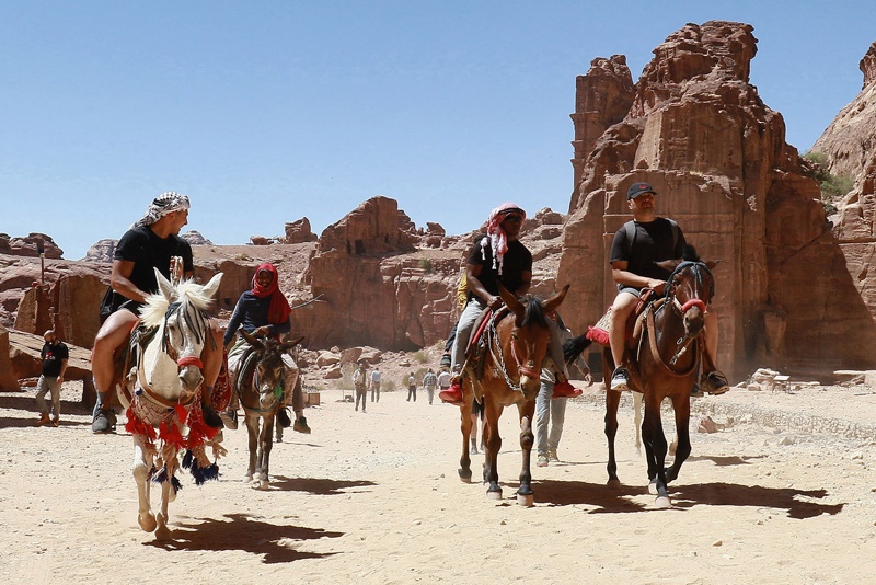 Tourists ride donkeys and horses as they visit Jordan's ancient city of Petra, after it reopened following closure due to the COVID-19 coronavirus pandemic. — AFP