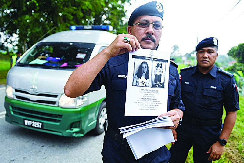 SEREMBAN: In this file photo taken on August 9, 2019 a Royal Malaysian Police officer holds a leaflet bearing a portrait of the missing 15-year-old Franco-Irish girl Nora Quoirin at a checkpoint during a search and rescue operation in Seremban. - AFPn