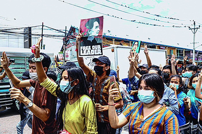 YANGON: Protesters make the three-finger salute and hold posters of Myanmar’s detained civilian leader Aung San Suu Kyi to mark her birthday as they take part in a demonstration against the military coup in Yangon yesterday. —AFP