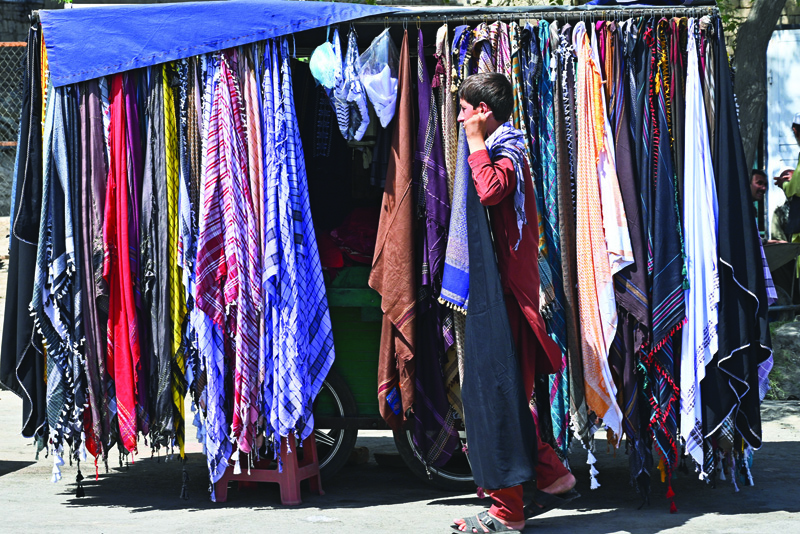 KABUL: A street vendor waits for customers along a road in Kabul yesterday. - AFPn