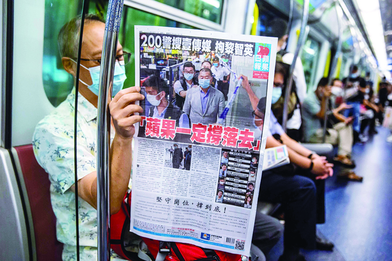 HONG KONG: File photo taken on August 11, 2020 shows a commuter reading a copy of the Apple Daily newspaper on a train in Hong Kong. Hong Kong's pro-democracy Apple Daily newspaper warned yesterday it is unable to pay staff and is at imminent risk of closure after the government froze the company's assets. - AFPnnn