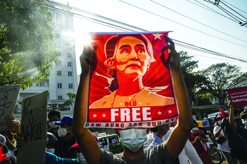 YANGON: In this file photo a protester holds up a poster featuring Aung San Suu Kyi during a demonstration against the military coup in front of the Central Bank of Myanmar in Yangon.-AFP n