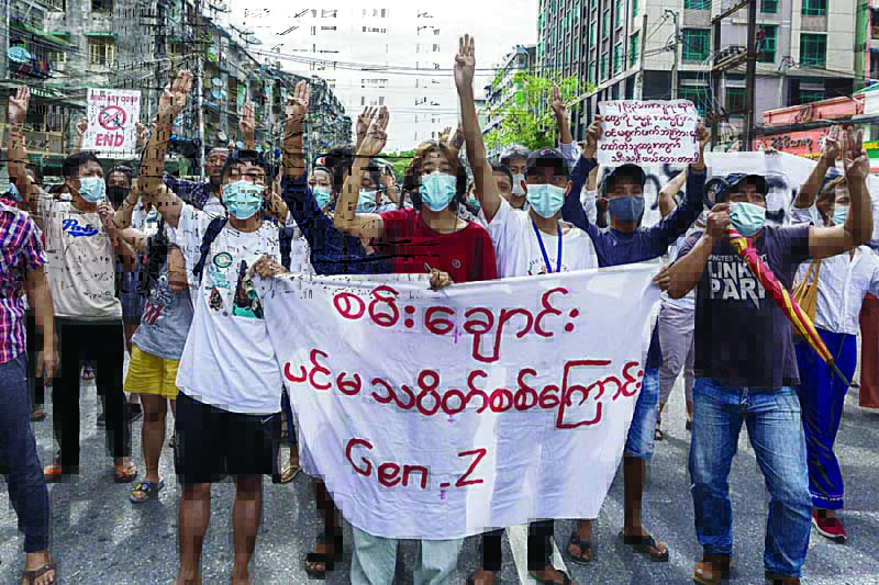 YANGON: Protesters make the three-finger salute as they take part in a flash mob demonstration against the military coup in Yangon yesterday.-AFPn