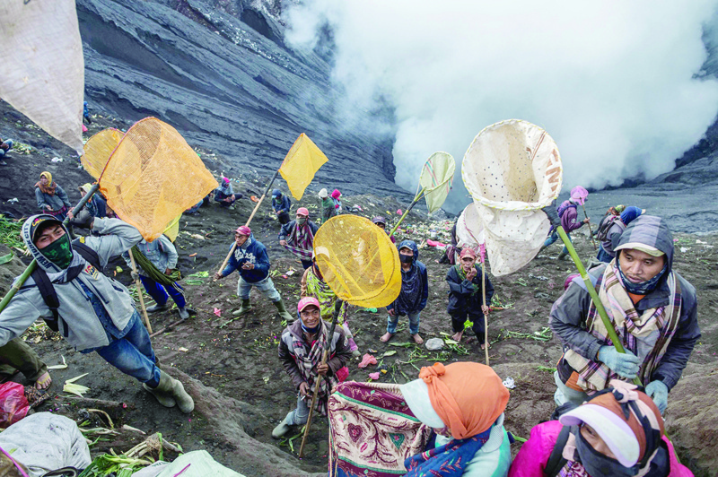 PROBOLINGGO, Indonesia: People try to catch offerings thrown by Tengger tribe people off the summit of the active Mount Bromo volcano in Probolinggo, East Java province yesterday. - AFP n