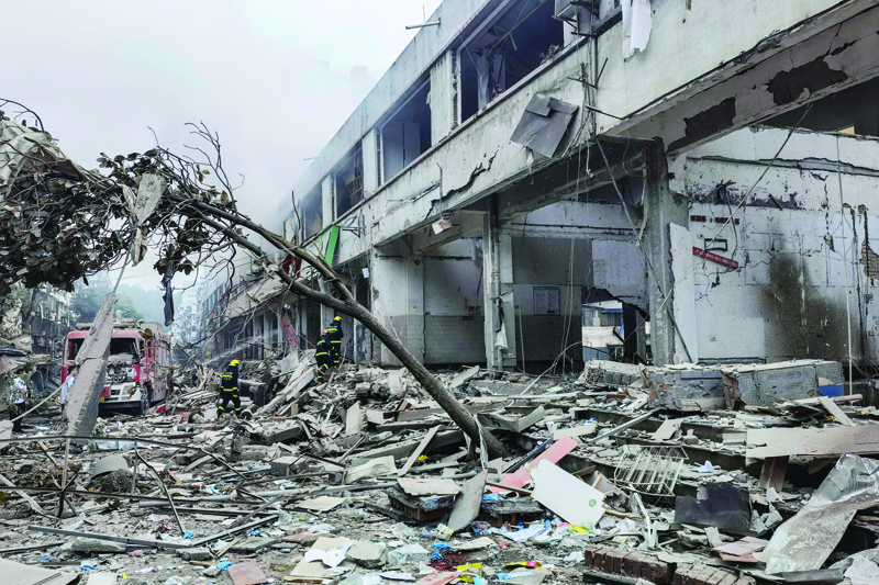 SHIYAN, China: Workers search for victims in a building damaged by a gas line explosion which left at least 12 people dead and nearly 140 others injured in Shiyan, in central China's Hubei province yesterday. - AFPn
