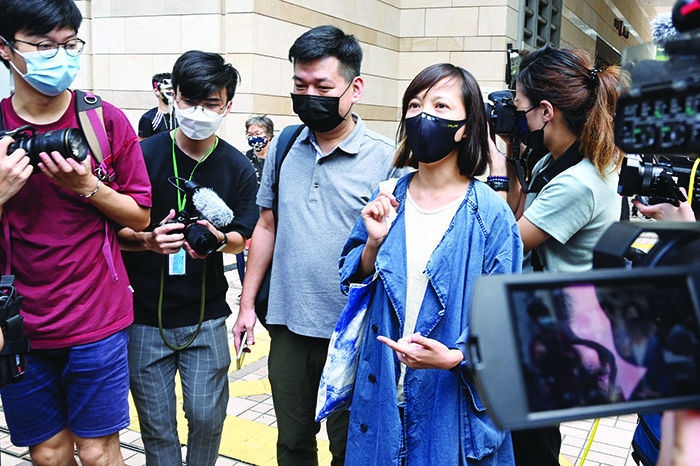 HONG KONG: Apple Daily deputy chief editor Chan Pui-man (centre R) gestures as she leaves court as fellow executives from the pro-democracy newspaper, chief editor Ryan Law and CEO Cheung Kim-hung were remanded in custody in Hong Kong yesterday. —AFP