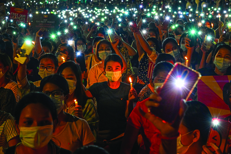 YANGON: Protesters hold up their mobile phones during a candlelight vigil to honor those who have died during demonstrations against the military coup in Yangon. – AFPn