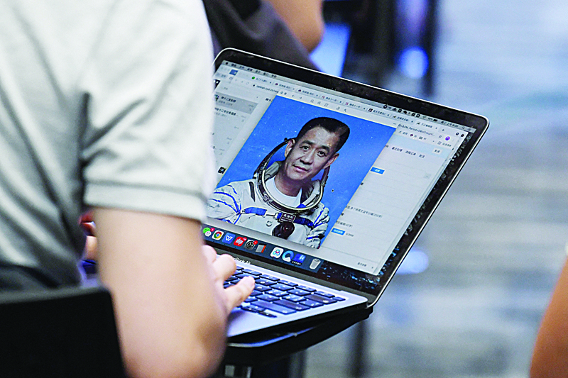 GOBI: A journalist looks at a photo of astronaut Nie Haisheng during a press conference about China's first crewed mission to its new space station at the Jiuquan Satellite Launch Centre in the Gobi desert in northwest China. – AFPnn