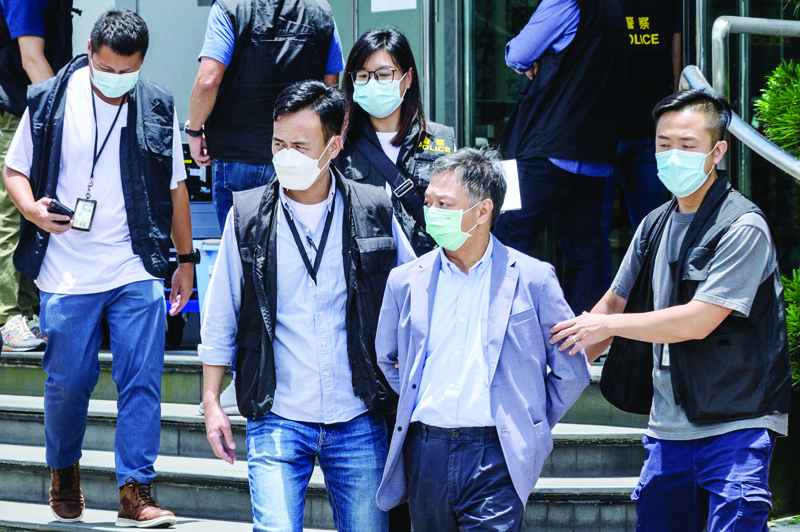 HONG KONG: Apple Daily Chief Operations Officer Chow Tat Kuen (2nd R) is escorted by police to a waiting vehicle from the offices of the local Apple Daily newspaper in Hong Kong yesterday, after Hong Kong police arrested the chief editor and four executives. - AFPnn