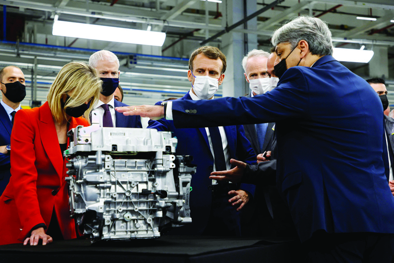DOUAI, NORD, FRANCE: French President Emmanuel Macron is shown an engine during a visit to the site of the future factory of Japan-based battery maker Envision AESC group, where Renault SA develops an electric-vehicle manufacturing hub, in Douai, northern France, yesterday. - AFPn