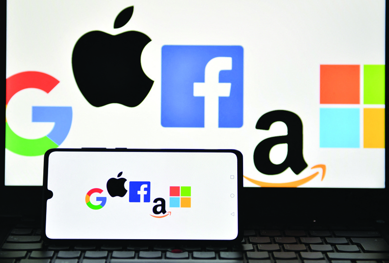 An illustration picture taken in London shows the logos of Google, Apple, Facebook, Amazon and Microsoft displayed on a mobile phone and a laptop screen. US lawmakers unveiled sweeping antitrust measures Friday aimed at tempering the dominance of Big Tech firms. - AFPn