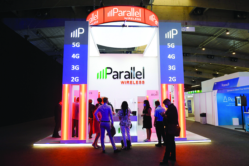 BARCELONA: People visit the Parallel stand at the Mobile World Congress (MWC) fair in Barcelona yesterday. -- AFP nnnnn