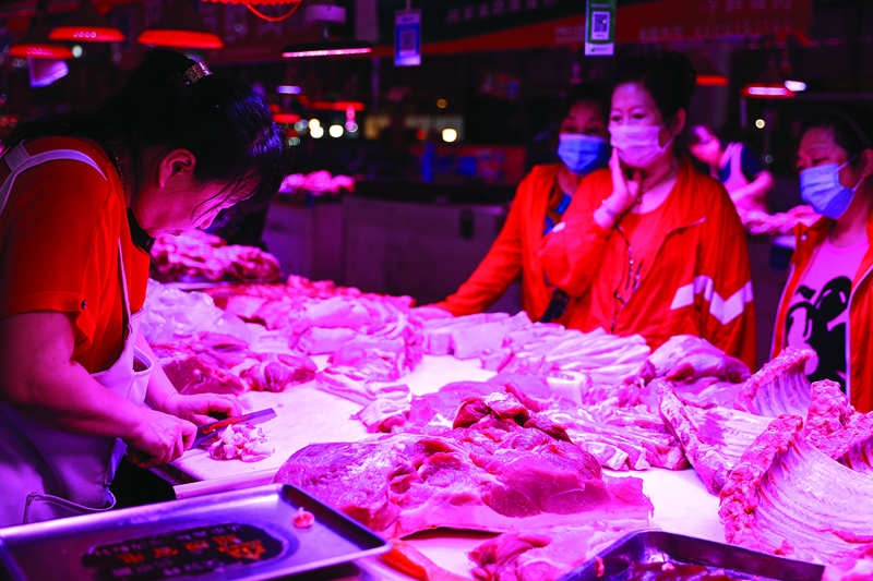 SHENYANG: A vendor cuts meat at a market in Shenyang in China's northeastern Liaoning province yesterday. — AFPn