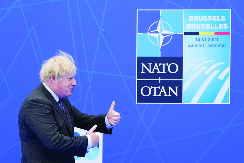 BRUSSELS: British Prime Minister Boris Johnson arrives to pose for photos with NATO Secretary General Jens Stoltenberg at the NATO summit at NATO headquarters in Brussels Sunday.-AFPn