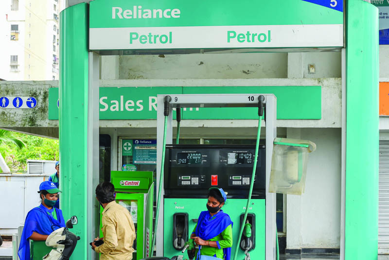 Employees attend a customer at the Reliance Industries Petrol pump in Navi Mumbai on June 24, 2021. n