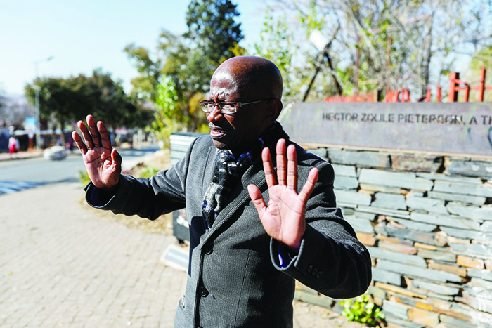 SOWETO: Seth Mazibuko gesturing while standing along a line that points to where Hector Pieterson was shot down in the street during the June 16, 1976 student uprising. —AFP