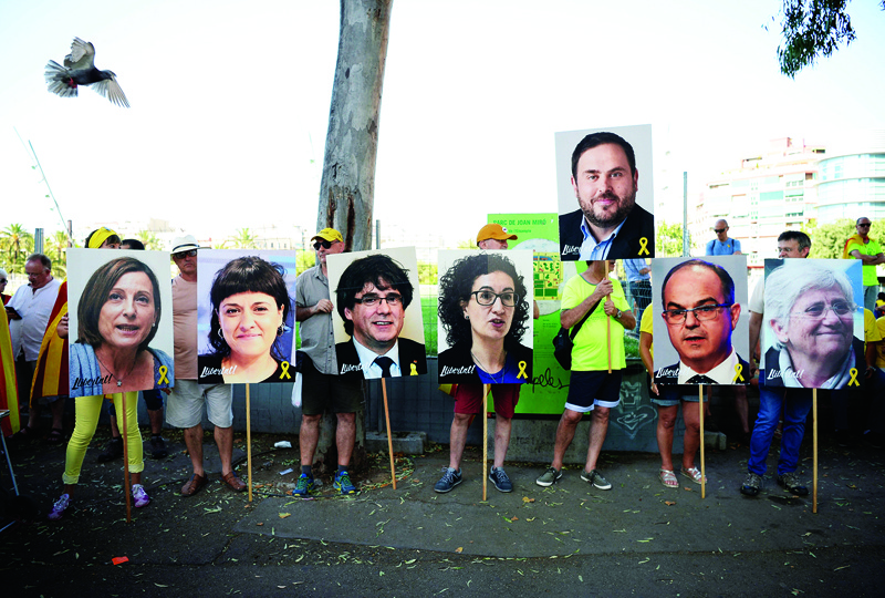 BARCELONA: File photo taken on July 14, 2018 shows people hold pictures of Catalan leaders in jail or exiled (from left) Carme Forcadel, Anna Gabriel, Carles Puigdemont, Marta Rovira, Oriol Junqueras, Jordi Turull and Clara Ponsati during a demonstration in support of jailed Catalan leaders in Barcelona. – AFPnn