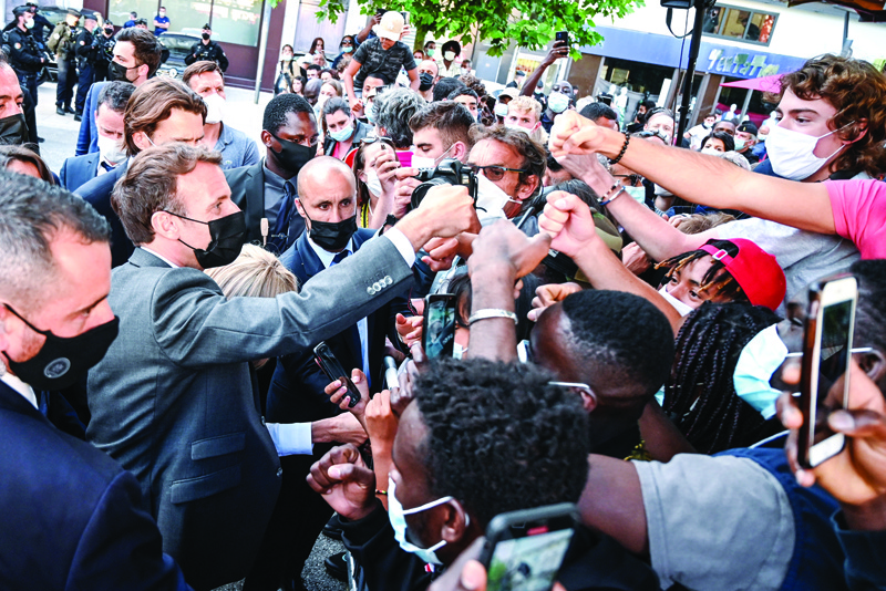 VALENCE: French President Emmanuel Macron (L) interacts with members of a crowd while visiting Valence during a visit in the French southeastern department of Drome, the second stage of a nationwide tour ahead of next year's presidential election. – AFPnnn