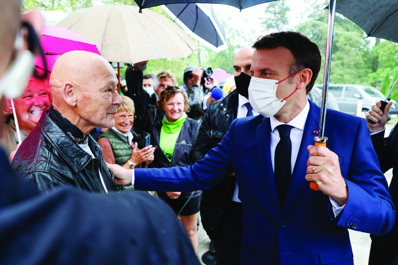 LE TOUQUET, France: French President Emmanuel Macron talks with a friend as he arrives at a polling station in Le Touquet, for the second round of the French regional elections yesterday. - AFPnn