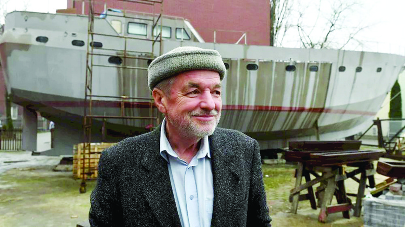 WARSAW: Ship Captain Waldemar Rzeznicki stands in front of a steel schooner called 'Father Boguslaw' under construction at the courtyard of a homeless shelter run by Catholic Fathers in Warsaw. - AFPn