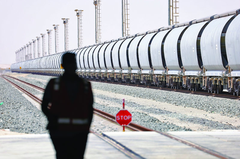 A picture taken on April 1, 2021 shows an employee standing near a train of the Etihad Rail network, in Al-Mirfa, in the UAE. - AFPn