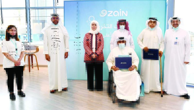KUWAIT: Zain's Eaman Al-Roudhan and Waleed Al-Khashti with a group of the honored students.n