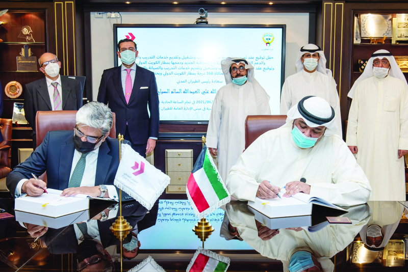 KUWAIT: DGCA President Sheikh Abdullah Ali Al-Sabah (right) and Indra representative in Kuwait Yahya Al-Shaibani sign the contract. - KUNAn