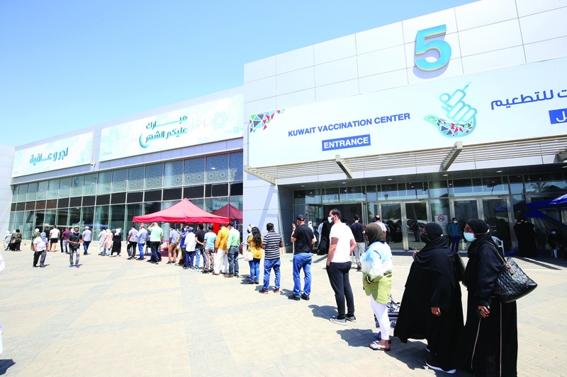 KUWAIT: This April 18, 2021 file photo shows people lined up outside the Kuwait Vaccination Center in Mishref to receive their doses of the COVID-19 vaccine. - Photo by Yasser Al-Zayyatn