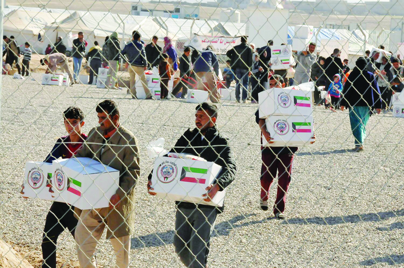 This handout photo released by Kuwait Red Crescent Society shows refugees collecting aid during a campaign organized by KRCS.n
