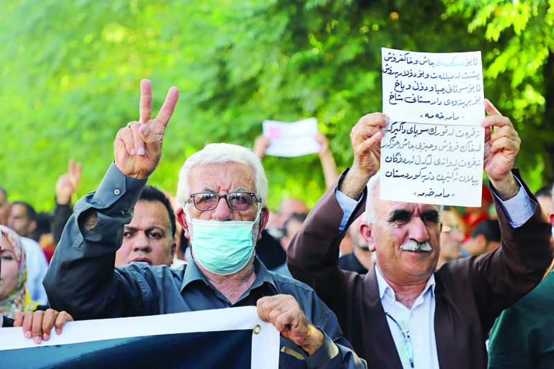 SULAIMANIYAH: File photo shows Iraqi Kurds lift banners and flash victory signs during a demonstration in the northeastern city of Sulaimaniyah on June 5, 2021, protesting a Turkish offensive in northern Iraq. - AFPnnn