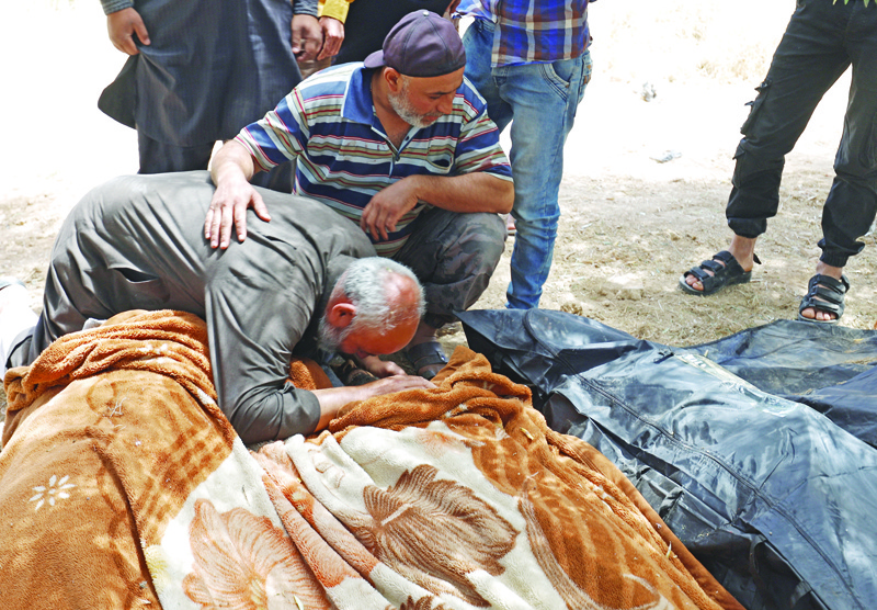 JABAL AL-ZAWIYA: Syrian man mourns over the body of a victim killed in reported bombardment by government forces on the village of Iblin in the Jabal al-Zawiya region in Syria's rebel-held northwestern Idlib province, yesterday. - AFPnn