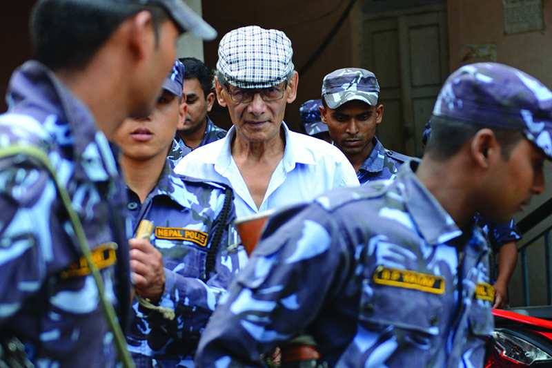 In this file photo taken on June 12, 2014, Sobhraj is escorted by Nepalese police at a district court for a hearing on a case related to the murder of Canadian backpacker Laurent Ormond Carriere in Bhaktapur. - AFPn