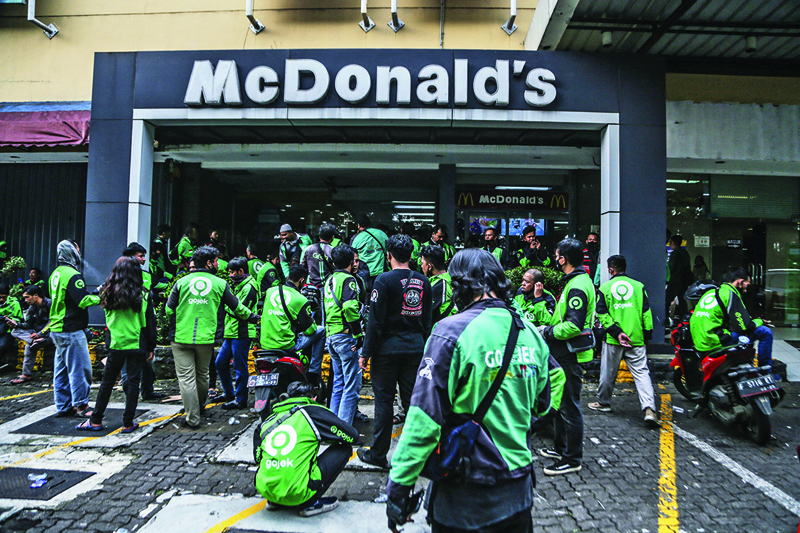 Food delivery riders make their way into a McDonald’s outlet in Bogor, to buy the new BTS-meal deal for hungry fans in the K-Pop mad country, causing more than a dozen McDonald's outlets to temporarily shuttered over virus fears. — AFPn